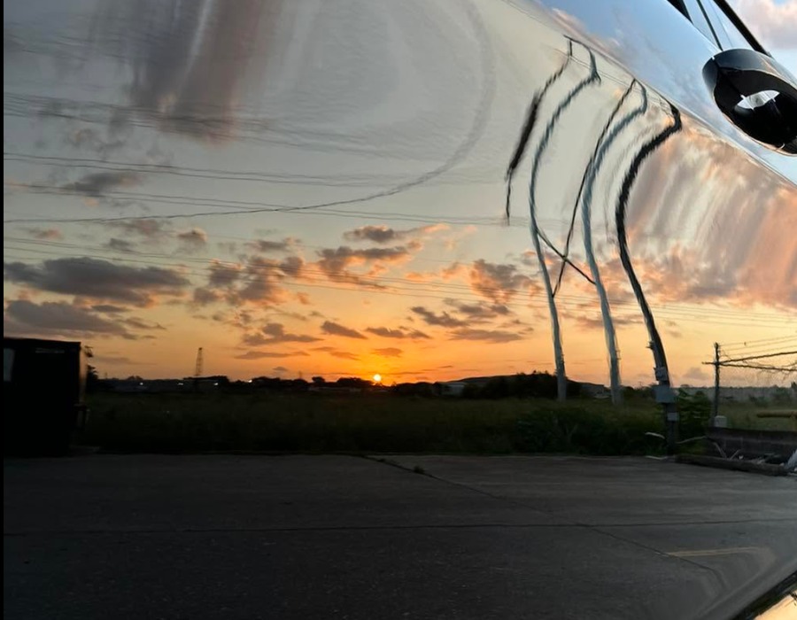Black SUV with mirror-like sunset reflection after paint correction